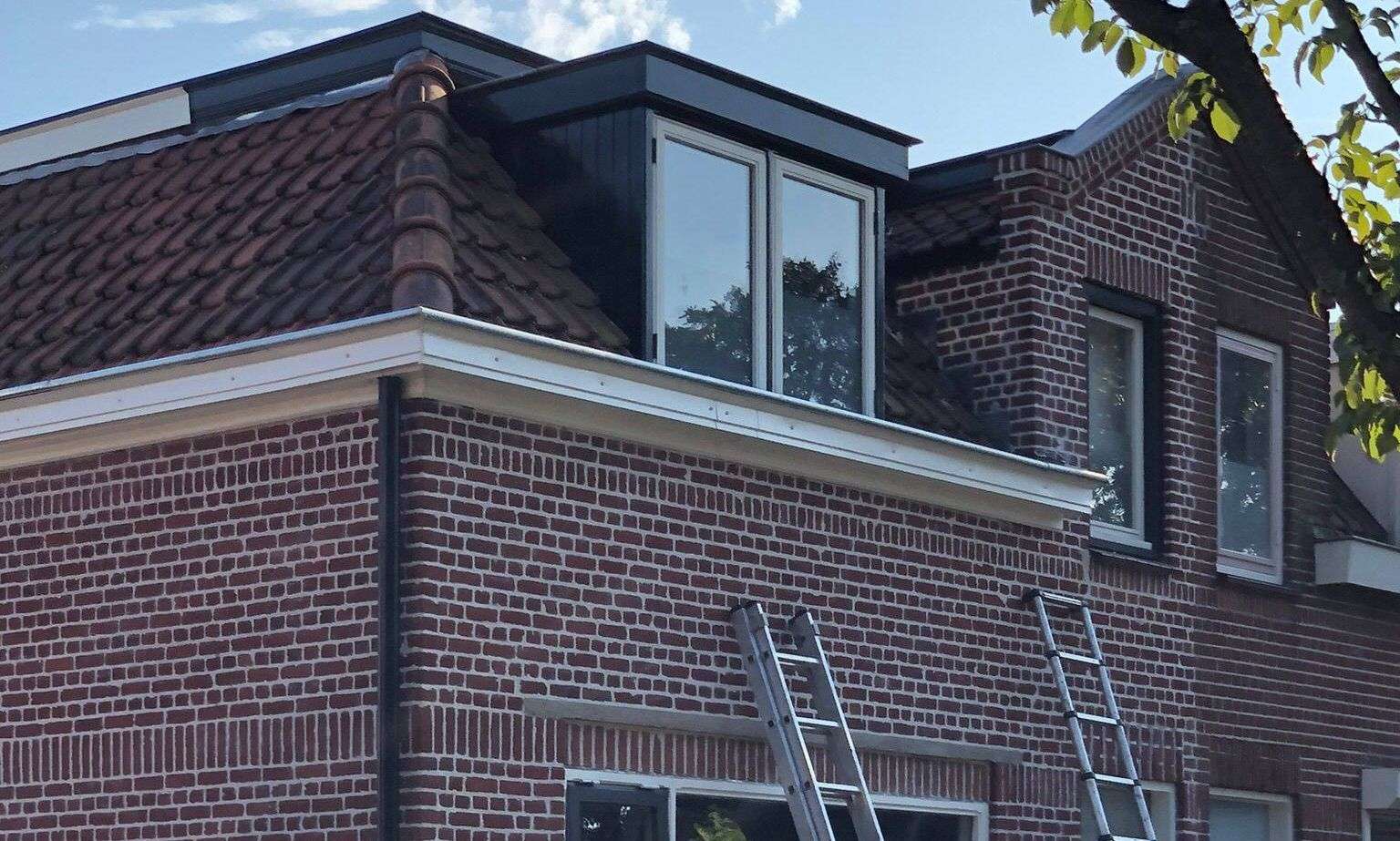 Met de ladden een dakgoot inspecteren in Helmond
